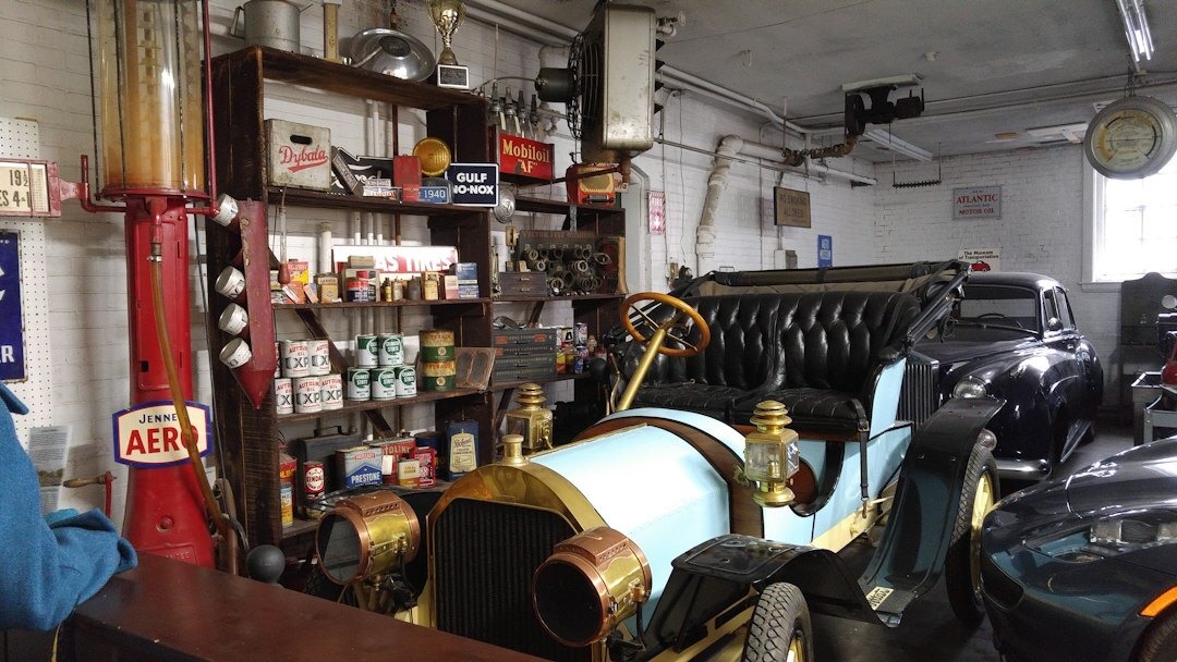 Private guide showing a visitor a vintage automobile collection inside an elegant garage