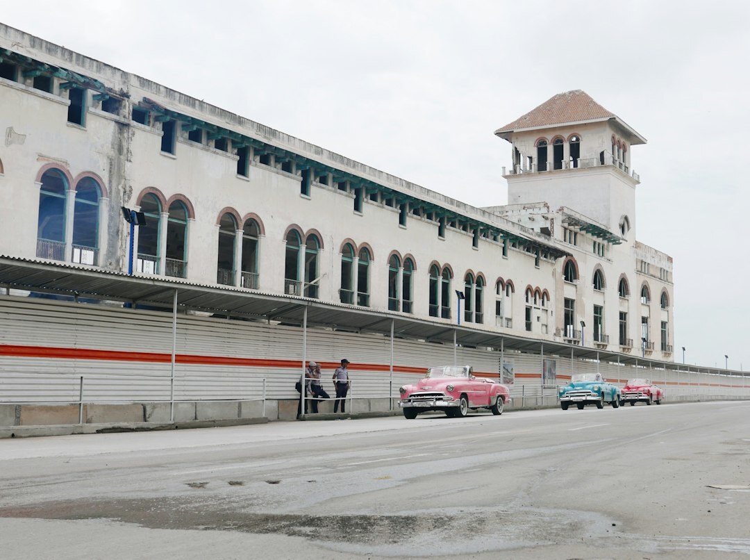 Line of classic rally cars parked on a plaza during a vintage car rally